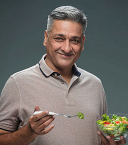 Elderly man happily walking in a park